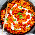 a pan of rice with vegetables and sauce